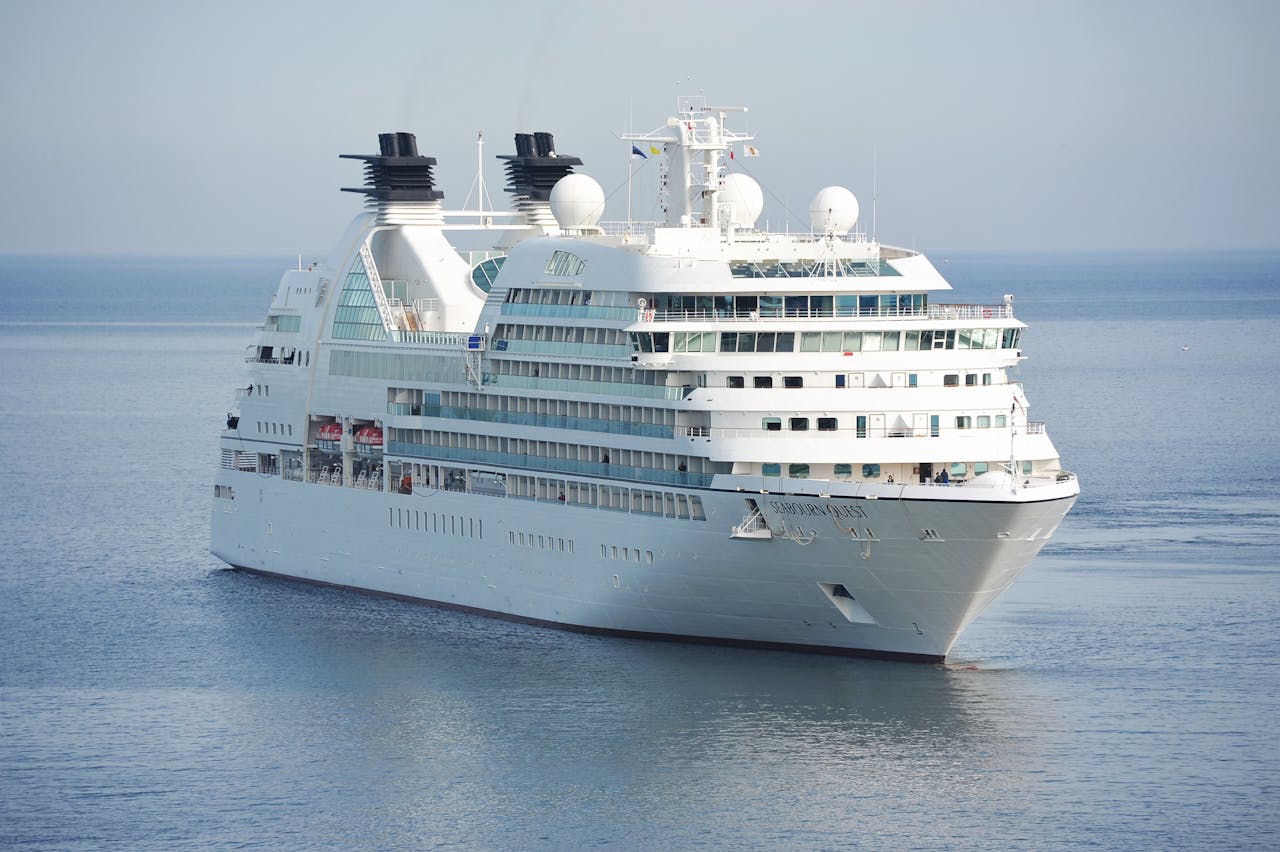 Elegant cruise ship sailing smoothly across tranquil waters under a clear sky.